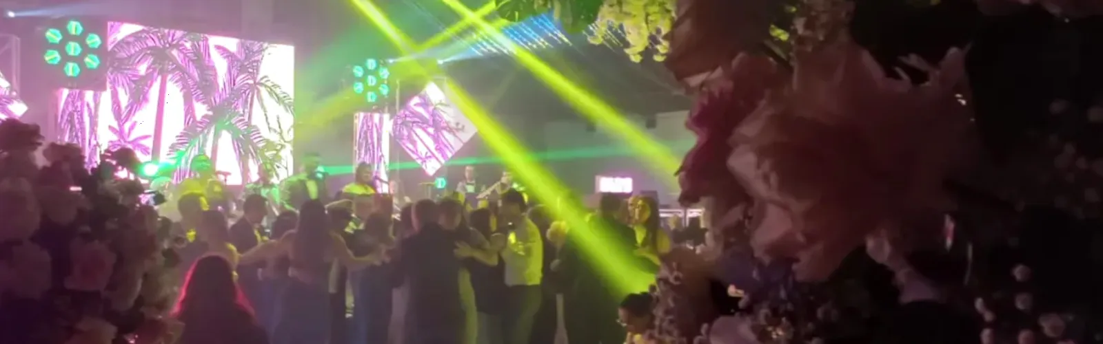 Pista de baile llena en una fiesta en Bogotá con láser, pantallas LED e iluminación de color
