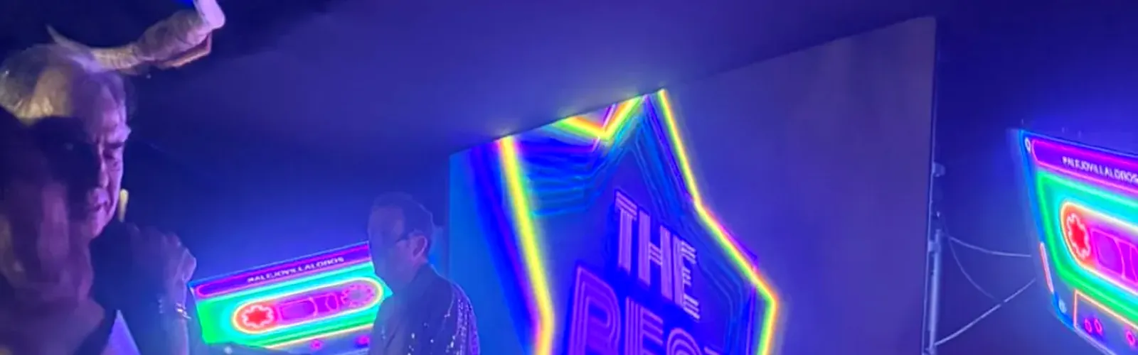 Fiesta temática en Bogotá con pantalla LED en neón, iluminación de color e invitados disfrazados