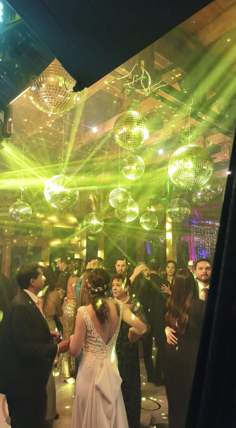 Boda con esferas disco doradas e iluminación sobre la pista de baile en Bogotá