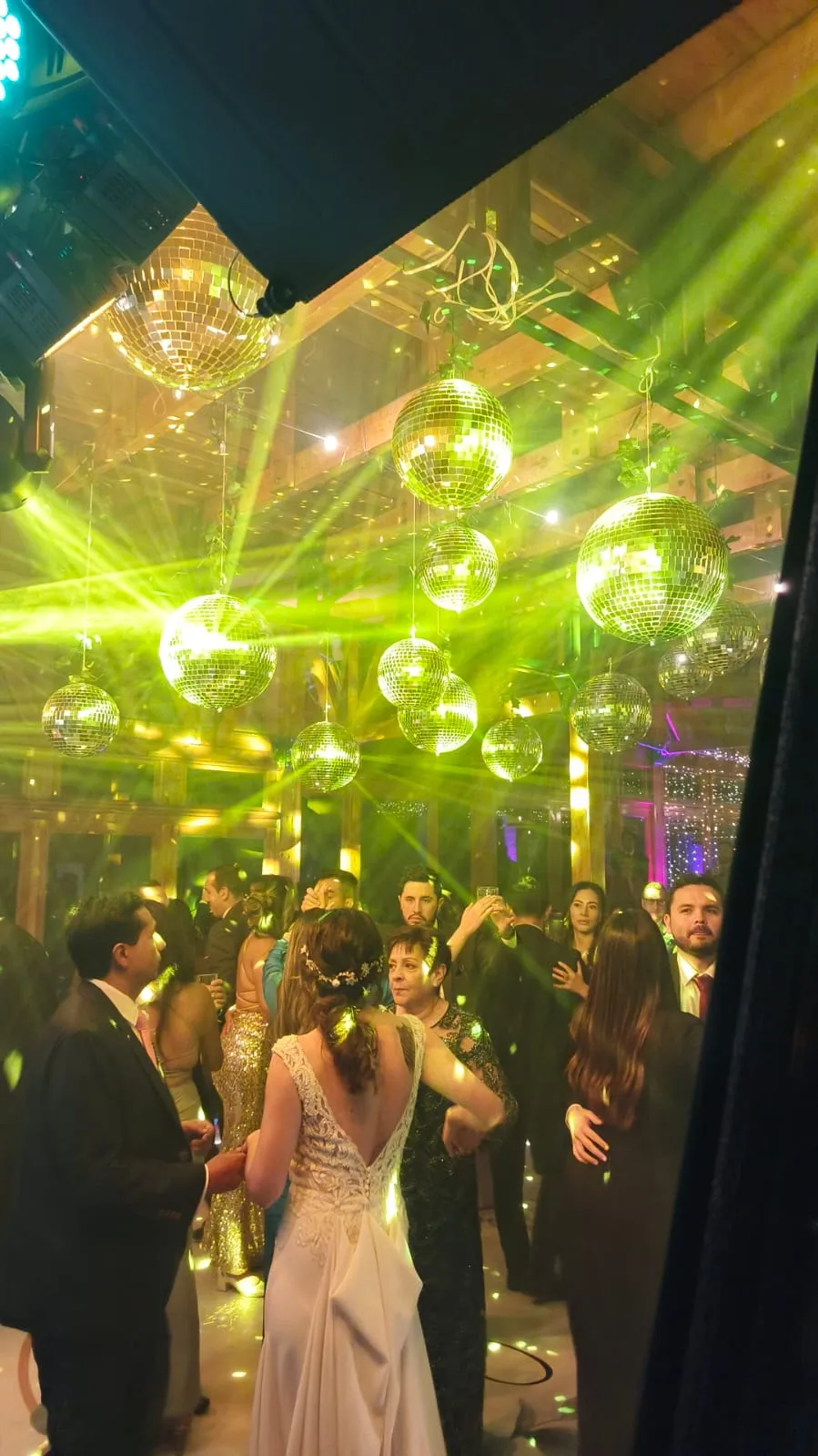 Esferas disco e iluminación verde sobre la pista de baile en una boda en Bogotá