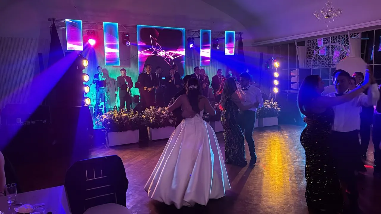 Primer baile de los novios con pantalla LED y banda en vivo en una boda en Bogotá