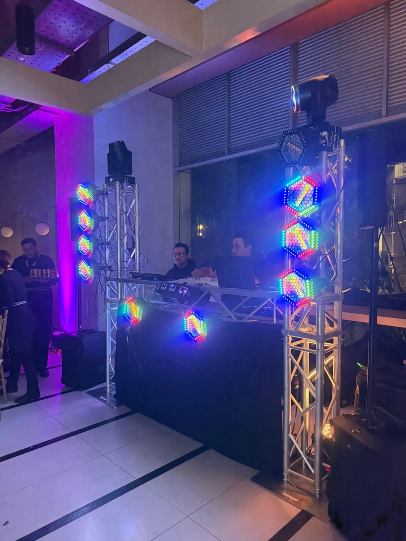 Cabina de DJ con torres de truss y paneles LED hexagonales de colores para evento en Bogotá