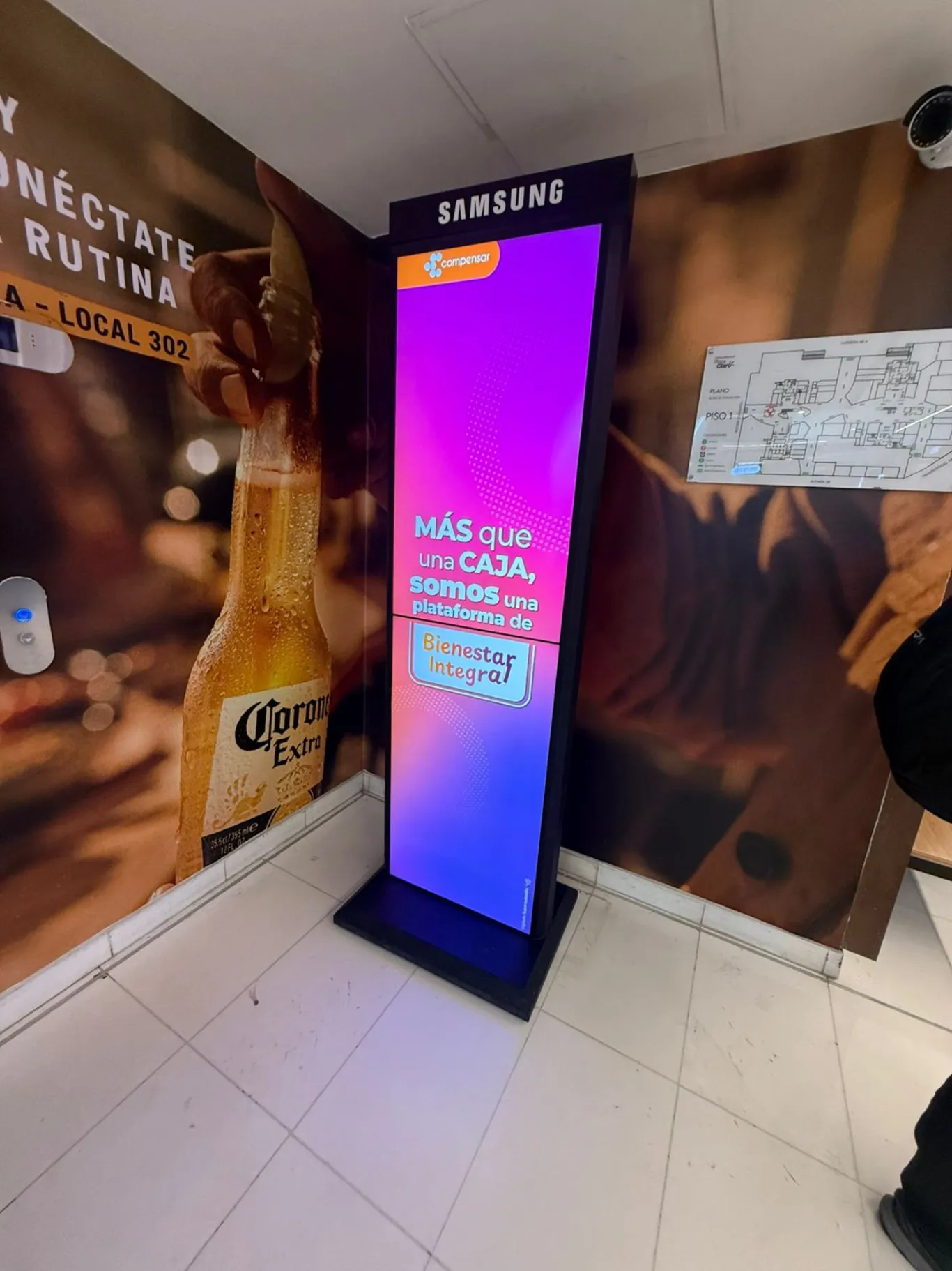 Tótem de pantalla digital vertical para activación de marca de Compensar en centro comercial de Bogotá